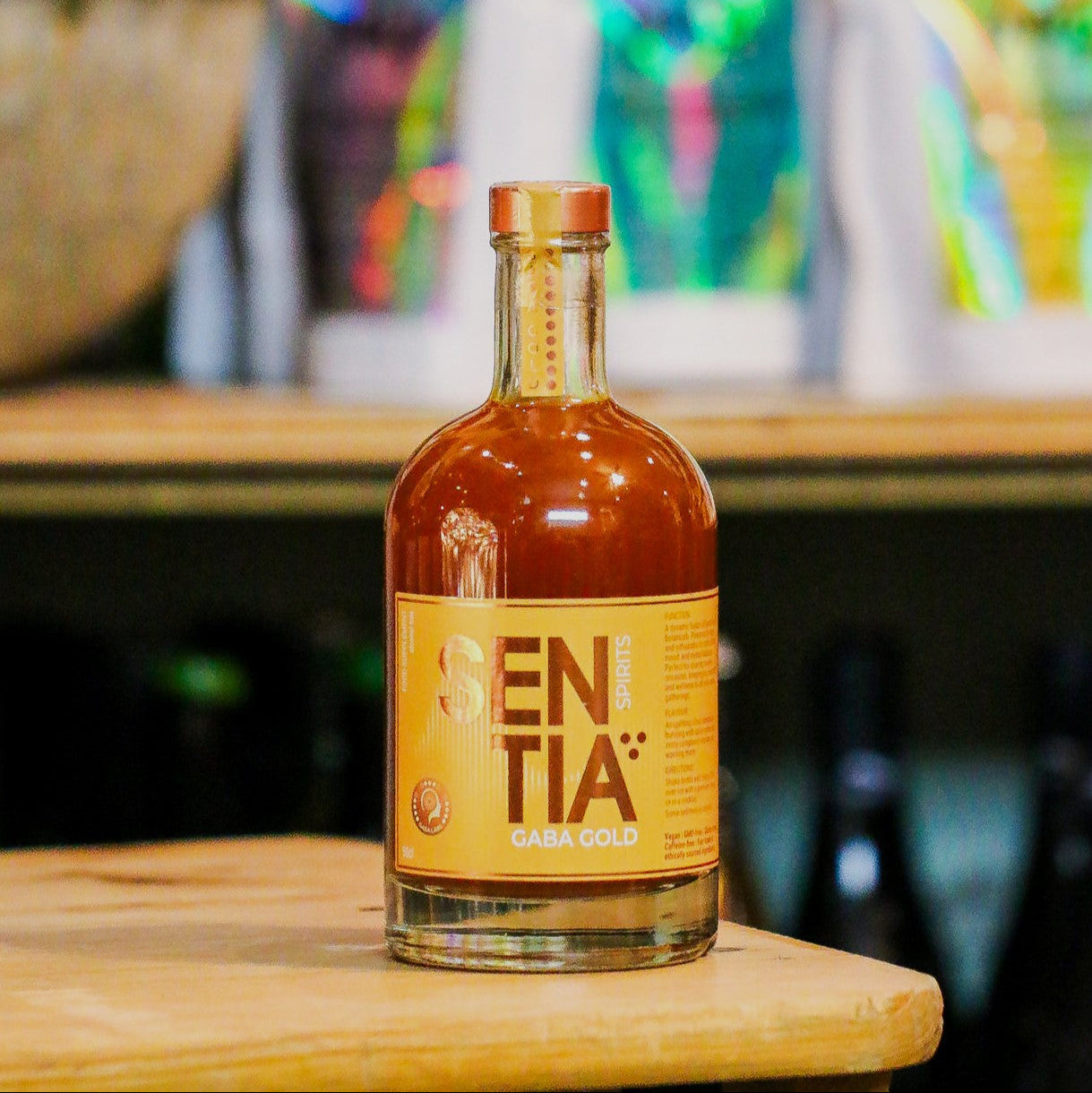 Bottle of Sentia Gold on a wooden surface with a blurred background