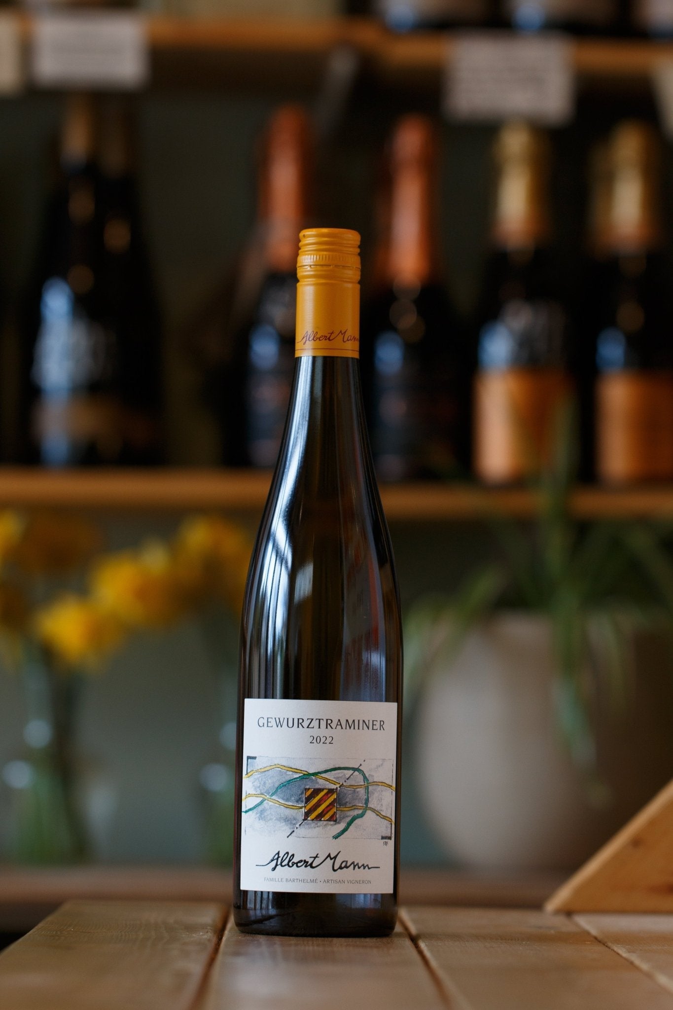 2022 Albert Mann Gewurztraminer - Organic, Vegan, Biodynamic White Wine from Alsace, France, displayed in a charming setting, highlighting its elegant bottle design.