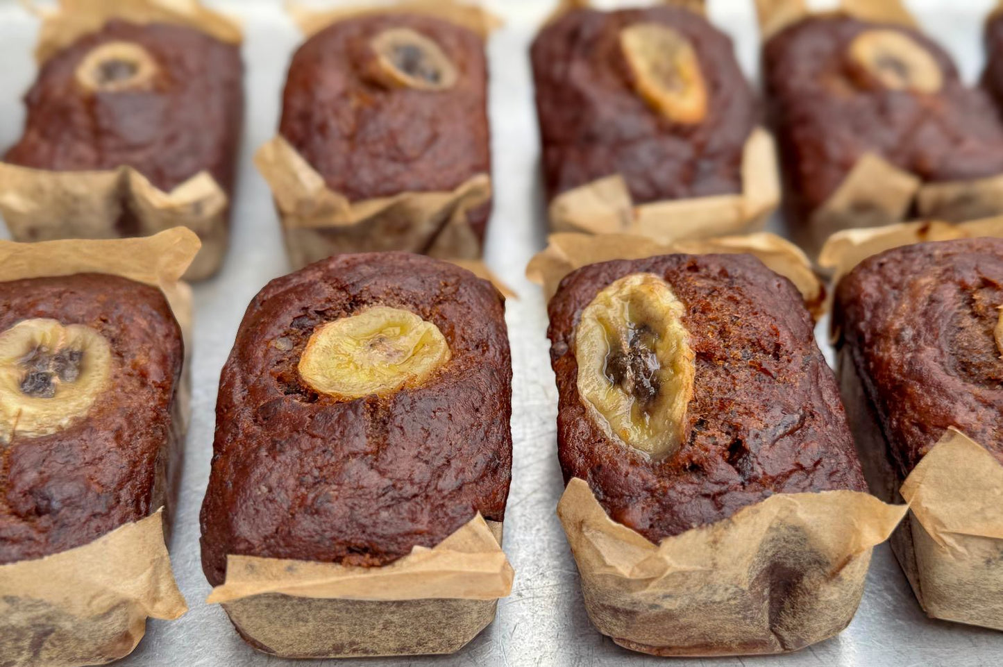 Delicious Vegan Mini Banana Bread Loaves by Pulp, featuring a close-up view of beautifully baked banana bread vegan mini loaves with golden banana slices, ideal for a delightful breakfast or snack!