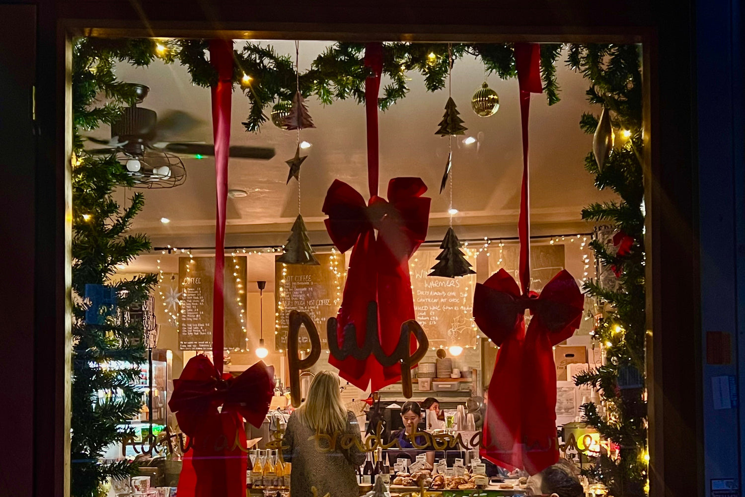 Indoors with Christmas decorations, including red bows and lights, in a festive setting.