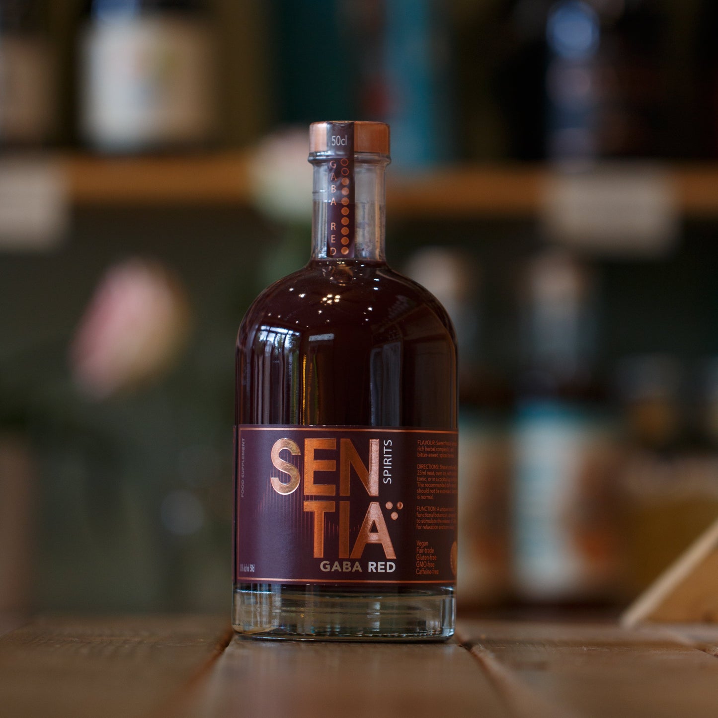 Bottle of Sentia Red on a wooden surface with a blurred background