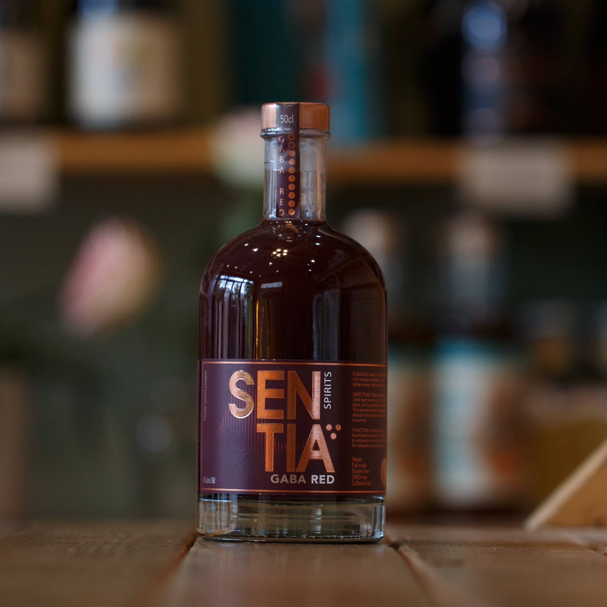 Bottle of Sentia Red on a wooden surface with a blurred background