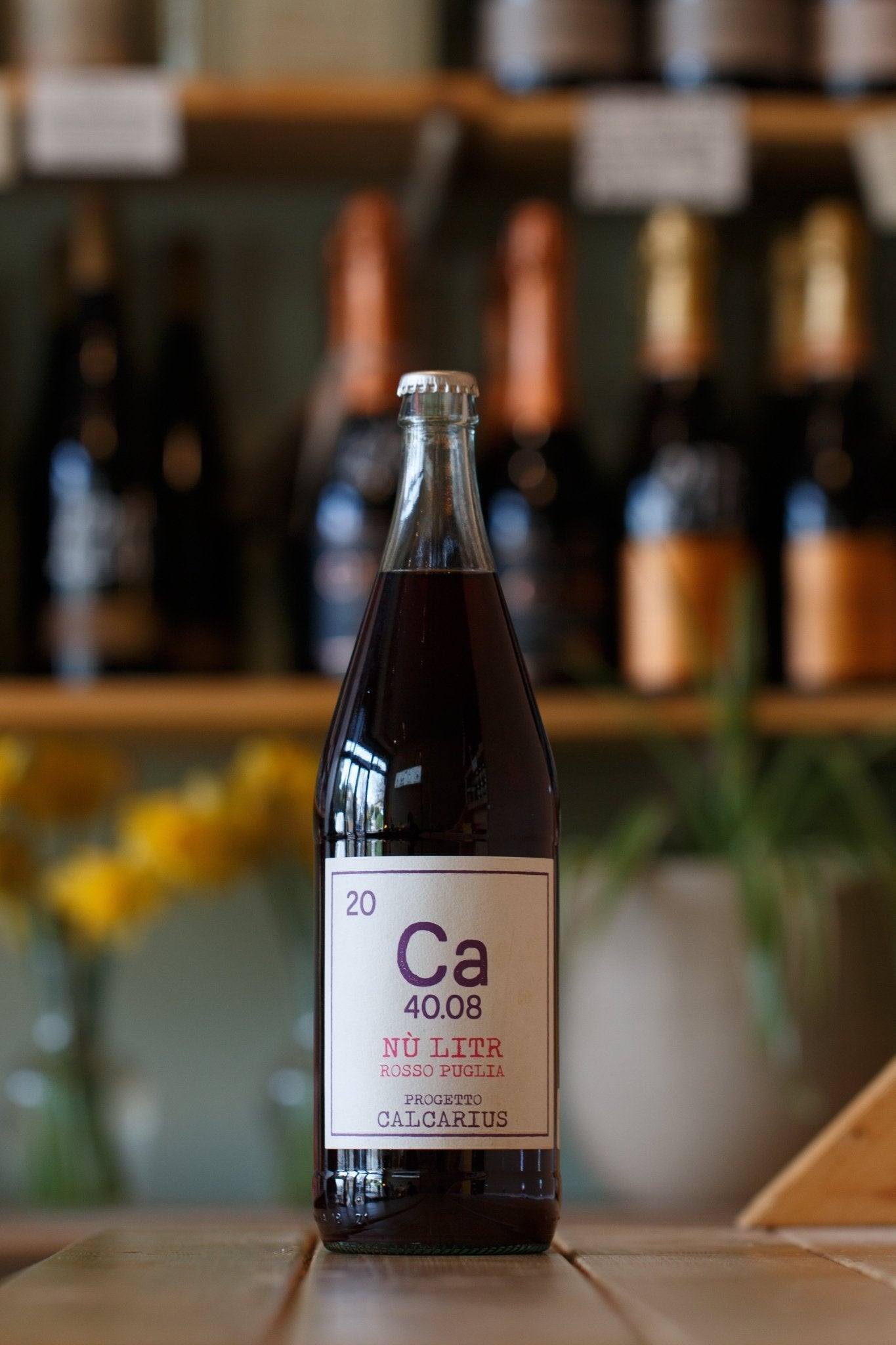 Fruity Vegan Negroamaro Red Wine bottle from My Store, labelled Ca 40.08, showcased against a backdrop of wine bottles, perfect for BBQs and parties.