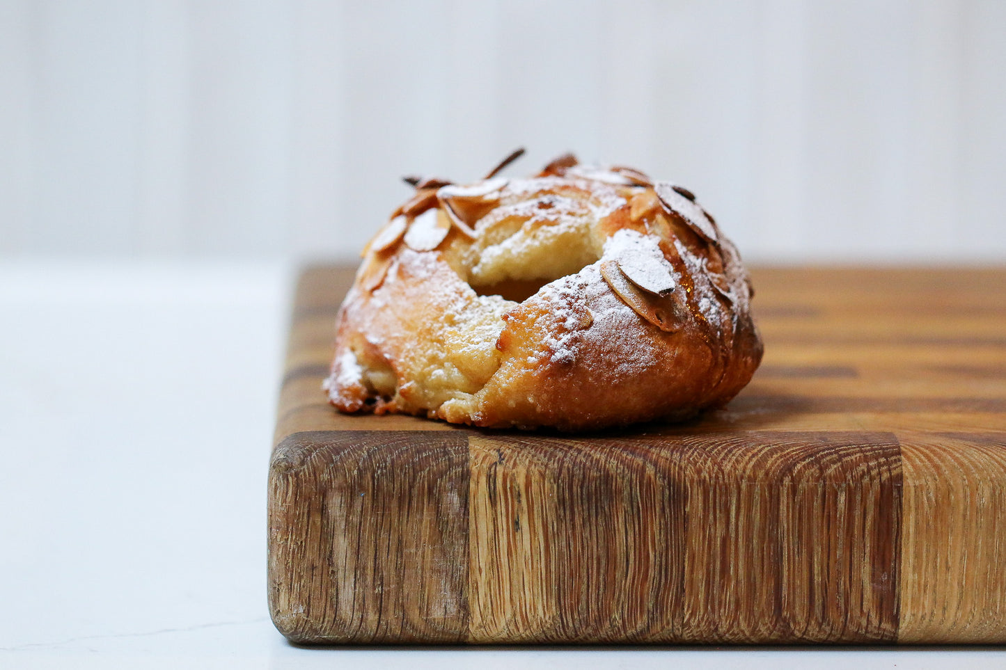 Pastry with powdered sugar on a wooden cutting board