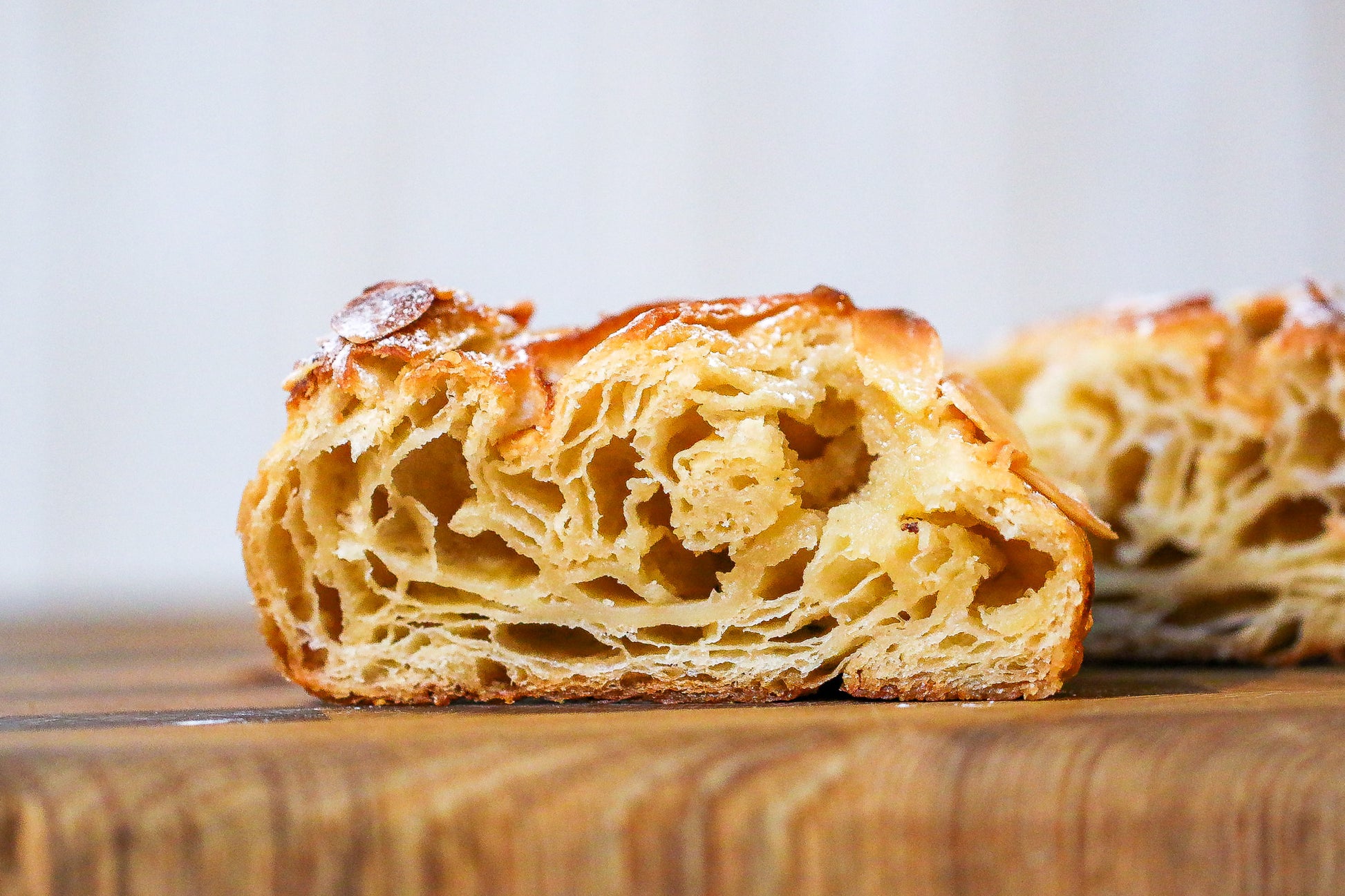 Close-up of a sliced pastry on a wooden surface with a blurred background